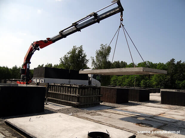 Załadunek szczelnego szamba betonowego do transportu  w Łomży